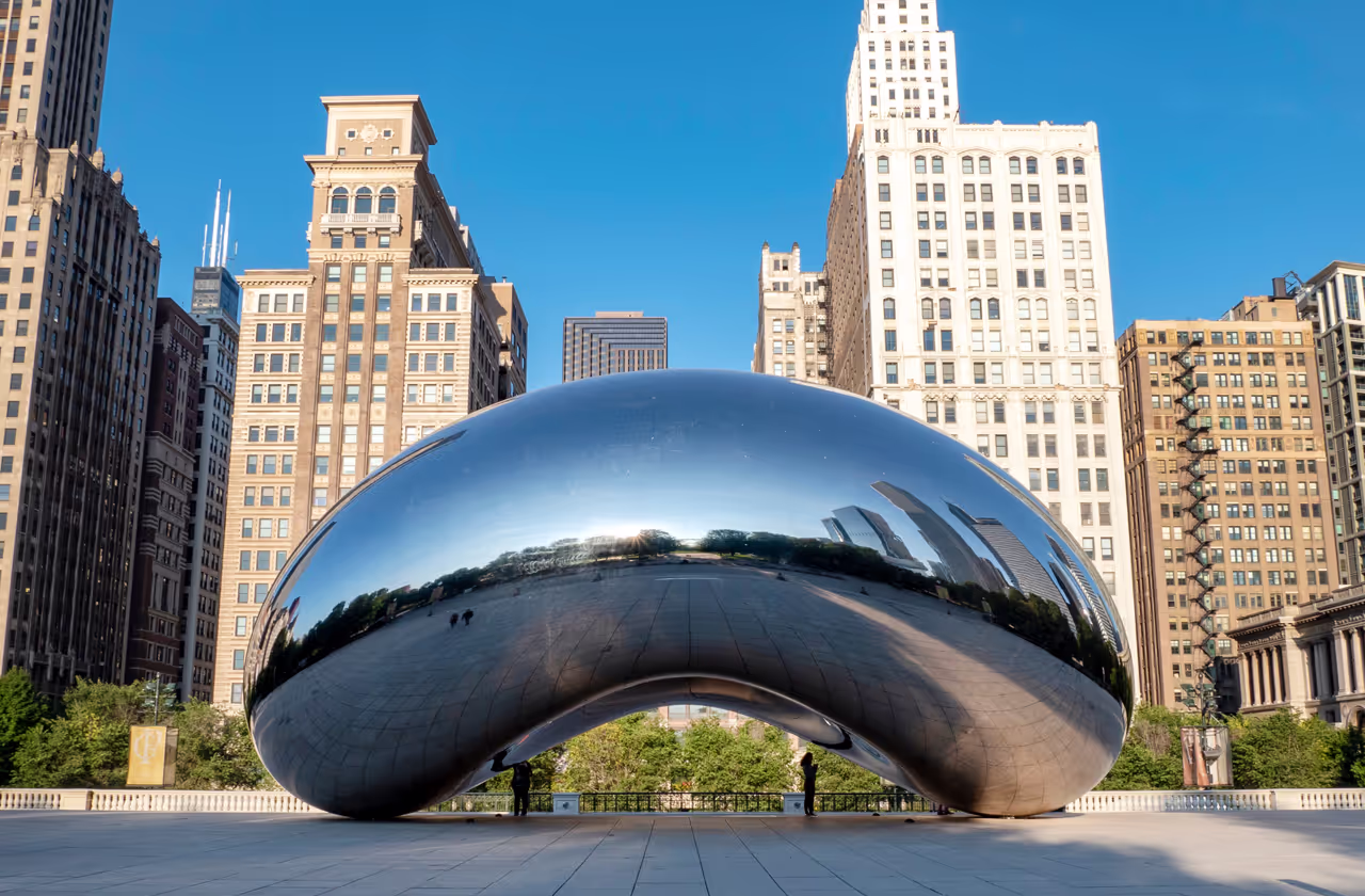 A large silver sculpture in a city park.